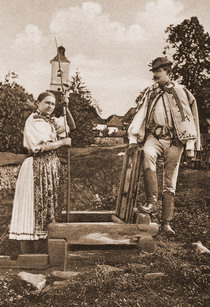 A couple drawing water from a well